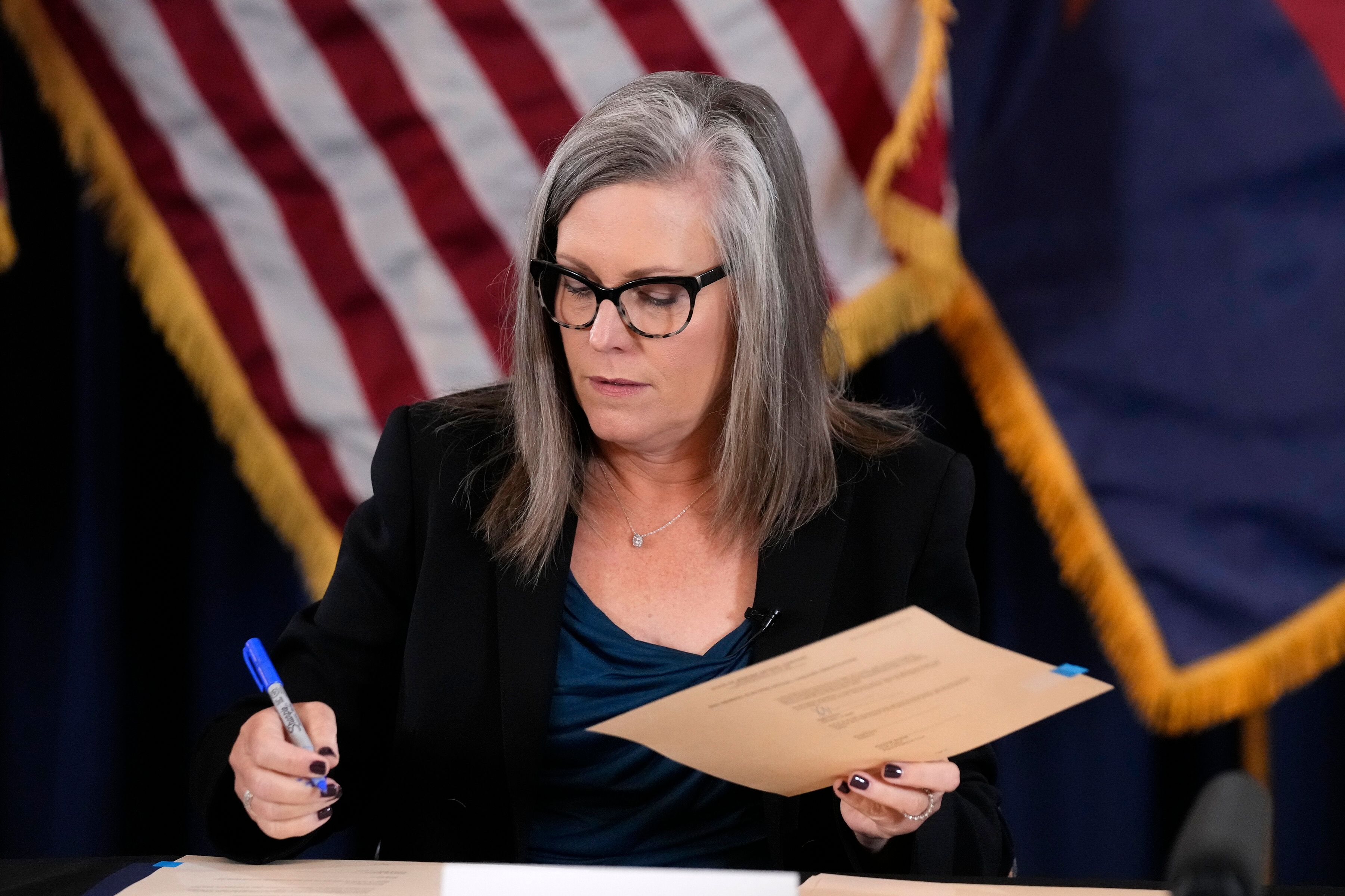 Katie Hobbs, the Democratic governor-elect and current secretary of state, signs the official certification for the Arizona general election canvass during a ceremony at the Arizona Capitol in Phoenix, on Dec. 5, 2022. 